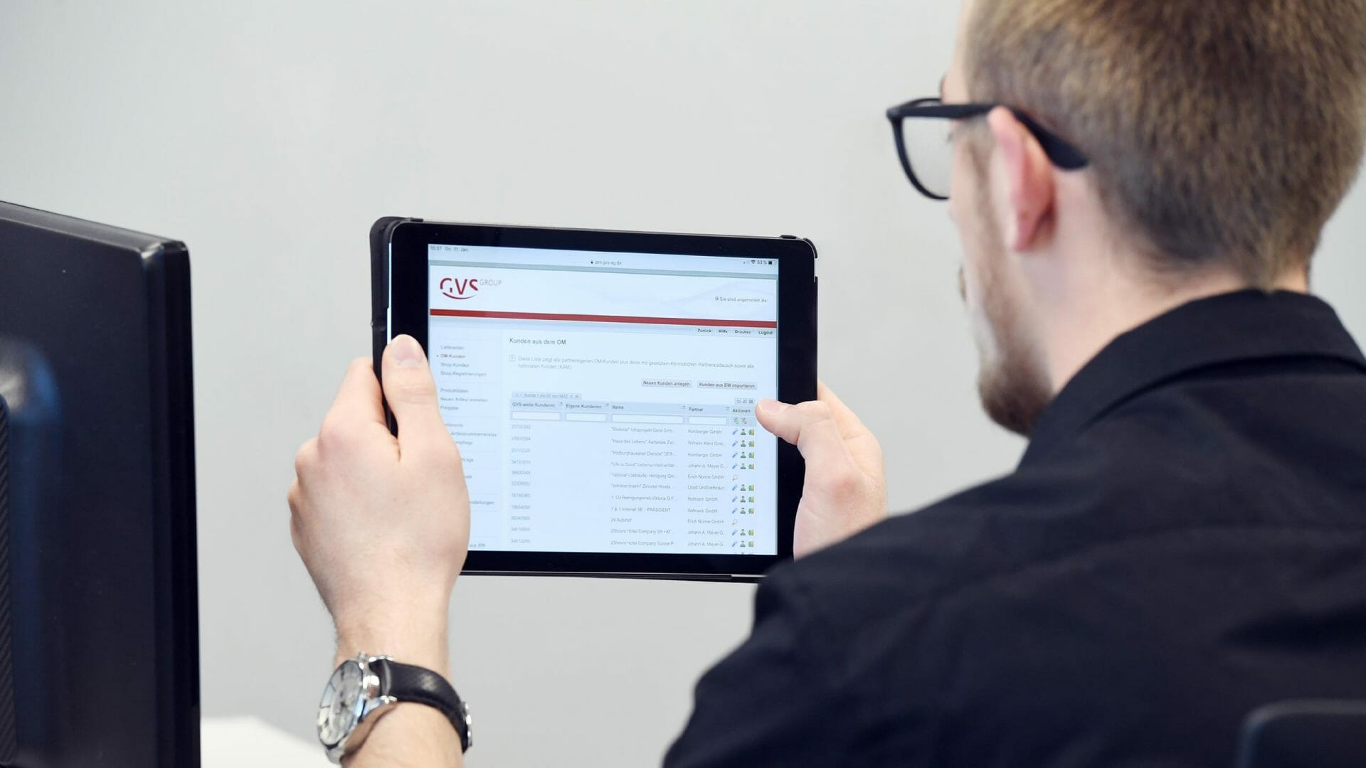 GVS Group-Mitarbeiter hält Tablet, das die Bestellplattform GVS-ORDERMANAGER für Großkunden zeigt